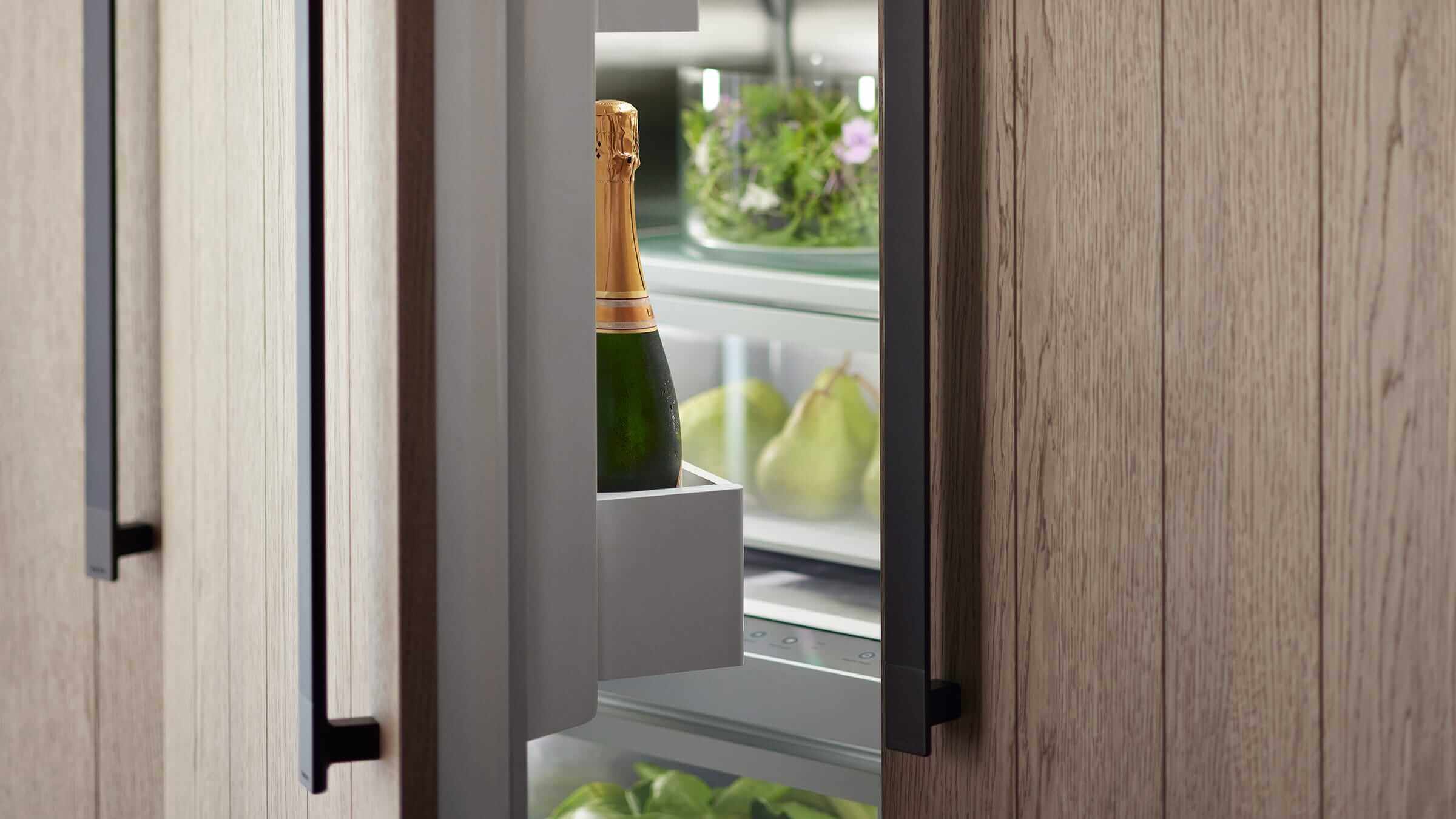 Contemporary kitchen with a person interacting with an integrated column refrigerator