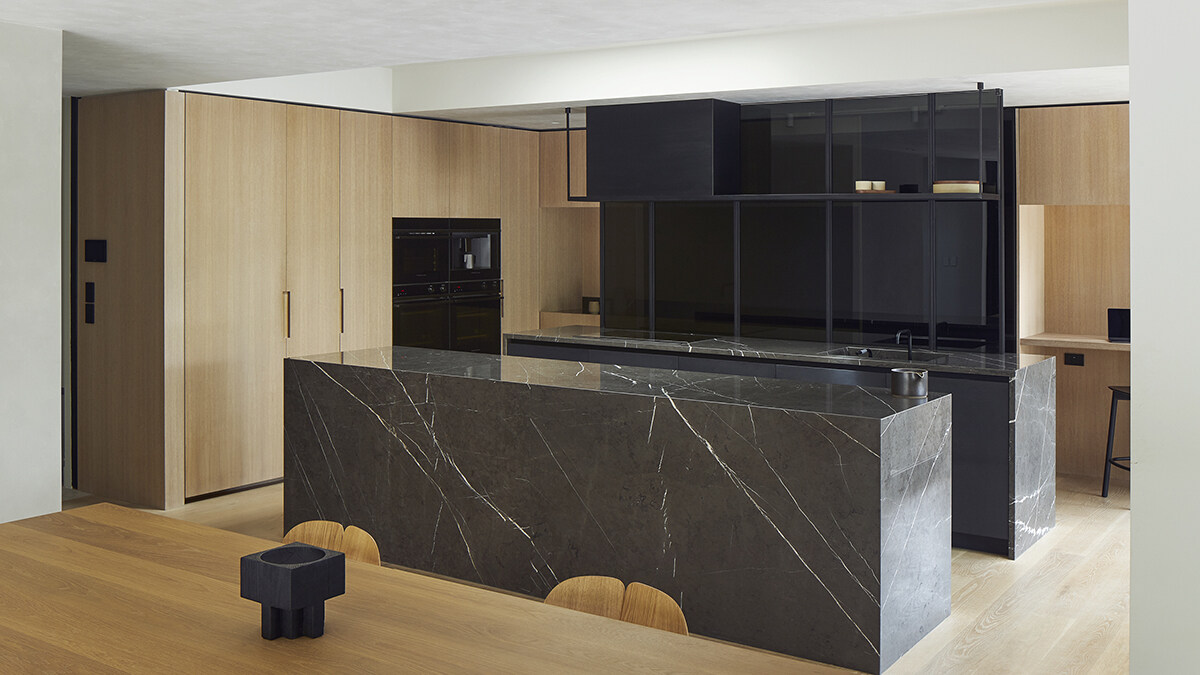 designer kitchen with black marble surfaces overlooking mix of Integrated & Minimal appliances