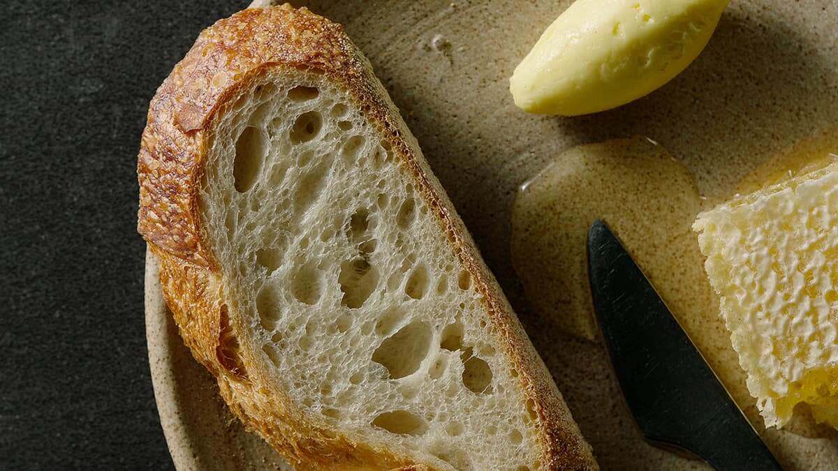 Buttered next to a warm loaf of sourdough bread