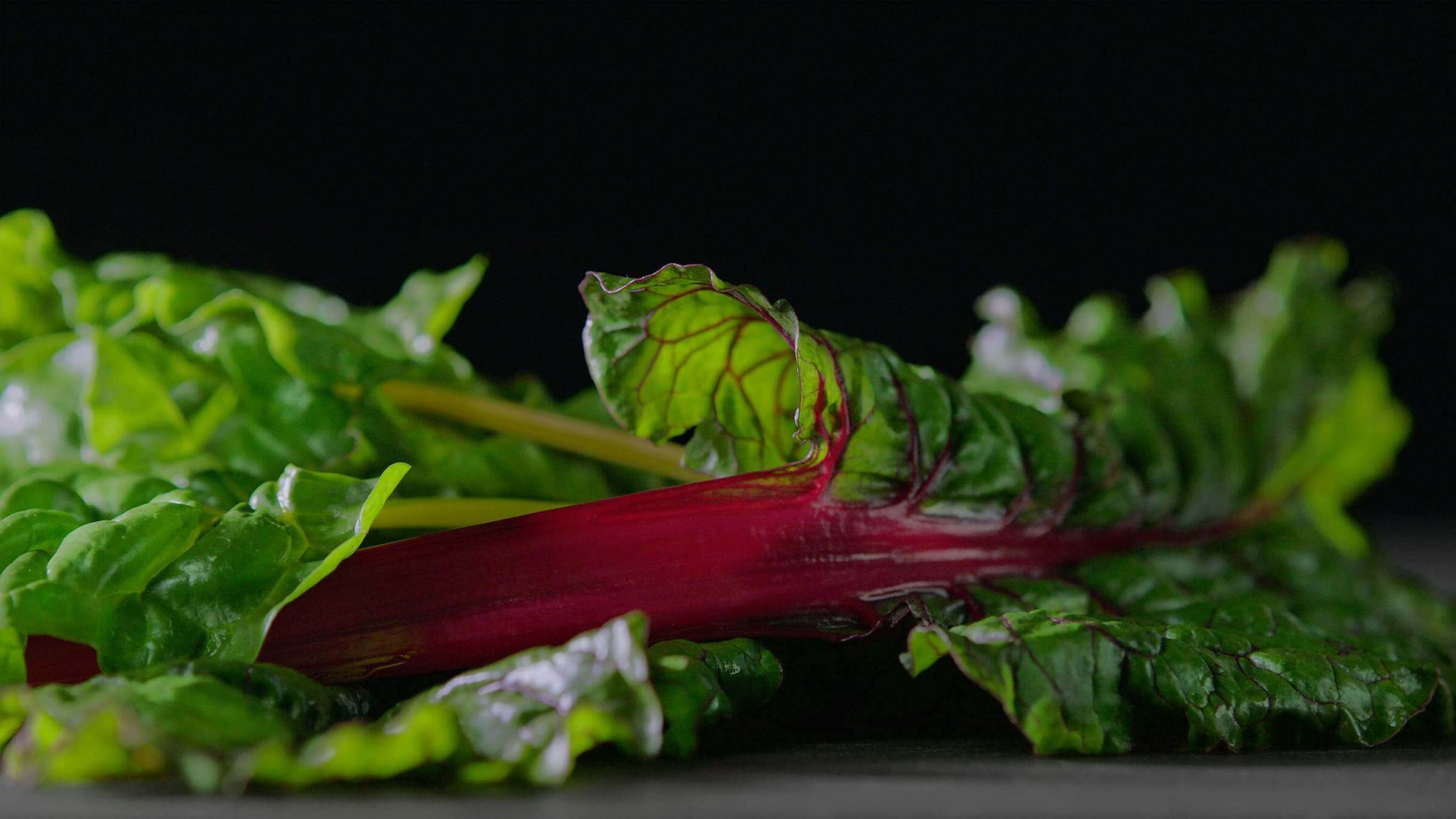 Fresh greens and vegetables stored in a specialized humidity-controlled refrigerator drawer
