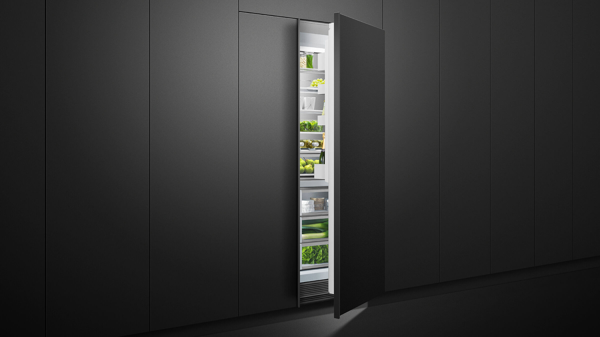 A trio of integrated refrigeration columns—freezer, refrigerator, and wine column—in a dark cabinetry wall