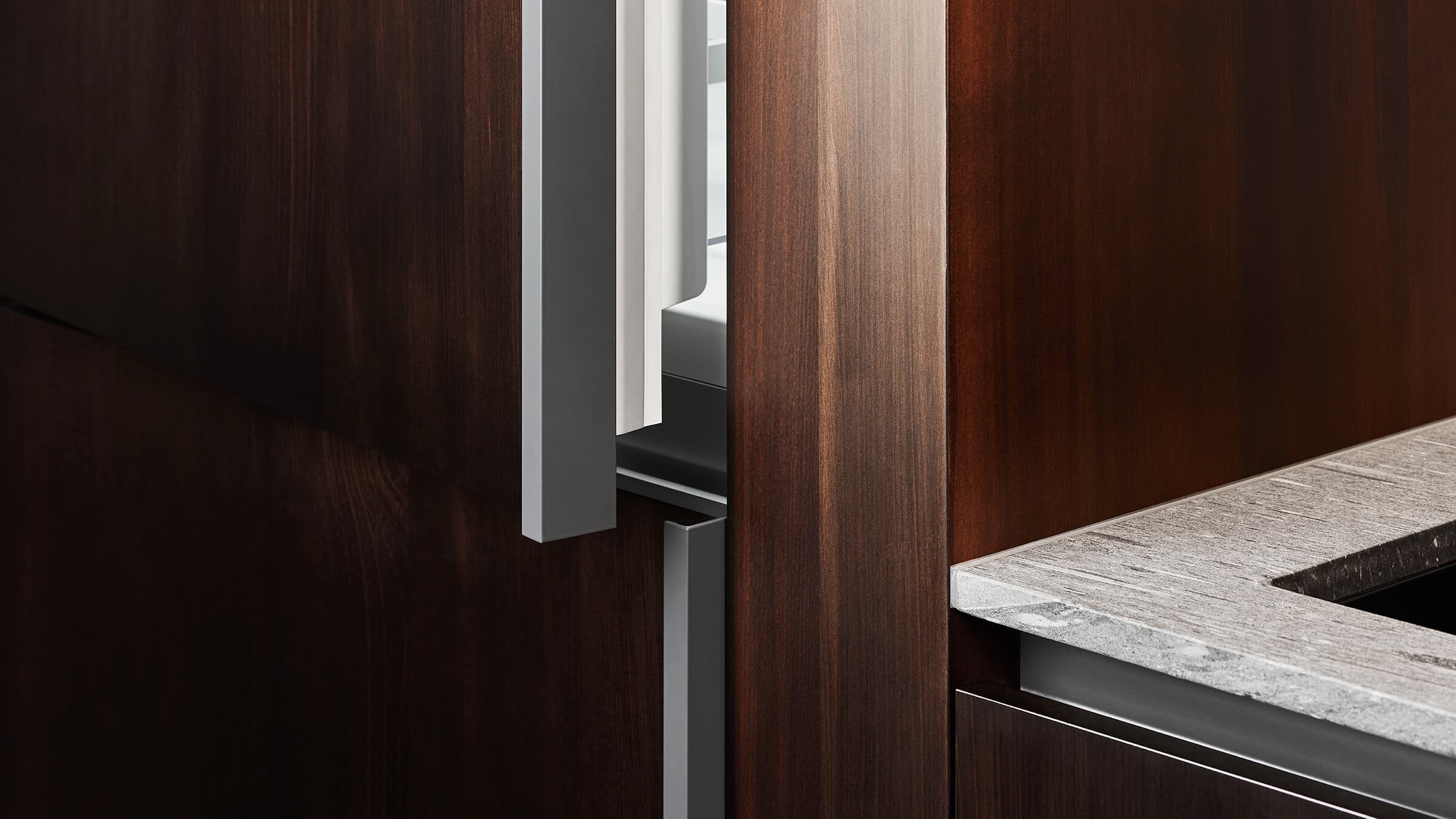 Integrated refrigeration seamlessly blended into a modern apartment kitchen cabinetry