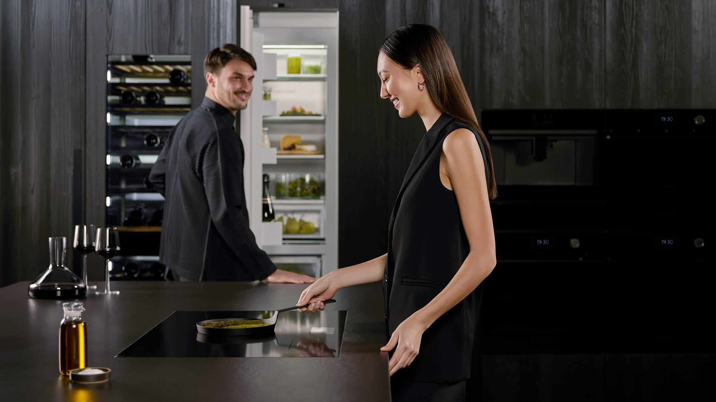 A minimalist kitchen showing the synergy between induction cooktop and integrated refrigeration